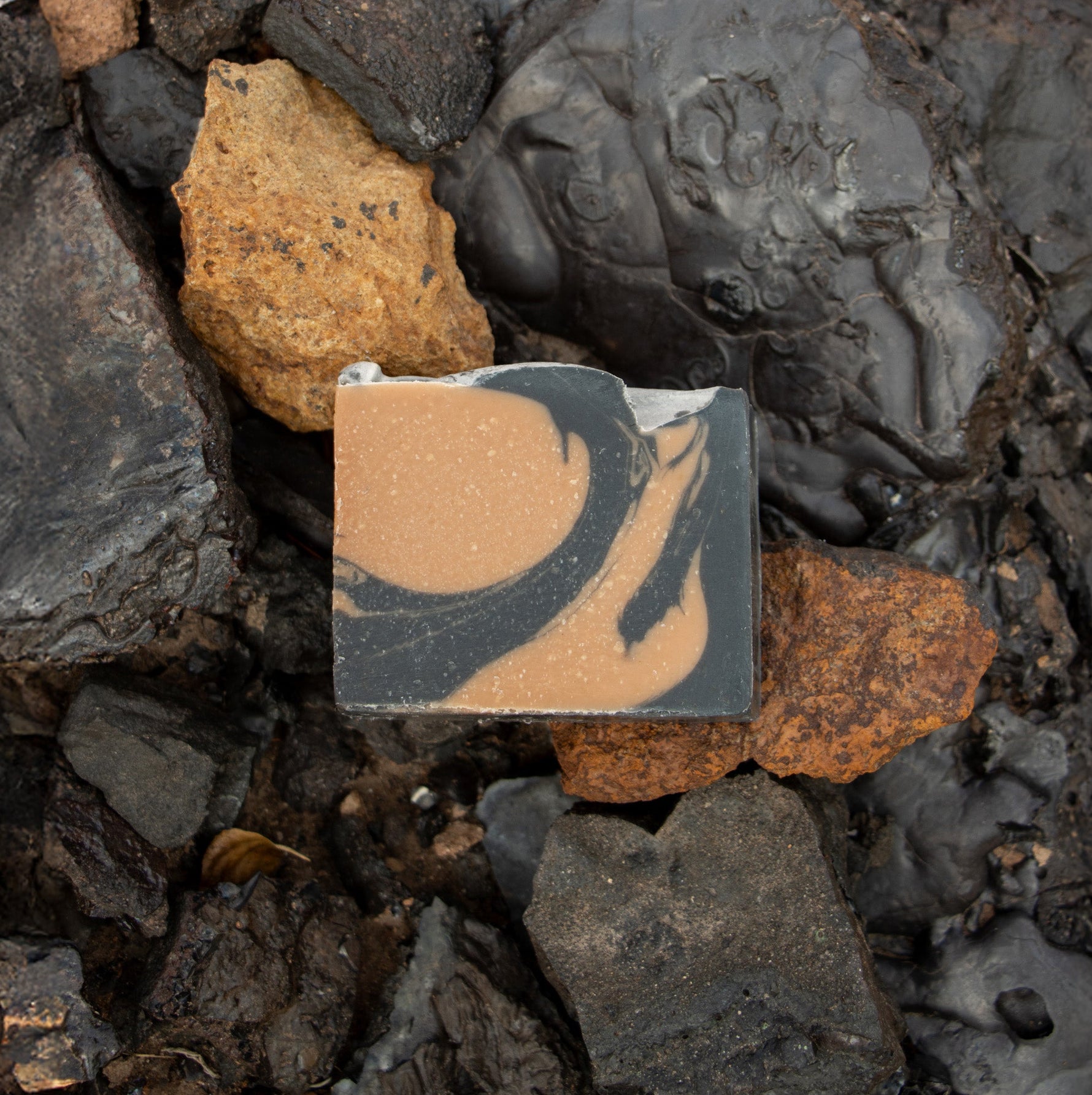 Bar of anaconda copper on a bed of multi colored rocks